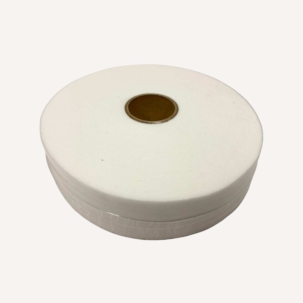 Close-up of a large white spool of thread with a brown center on a pale background, viewed from the side