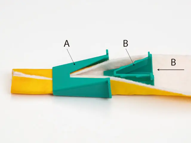 Two teal plastic clamp pieces gripping a yellow strip, labeled A and B, on a white surface.