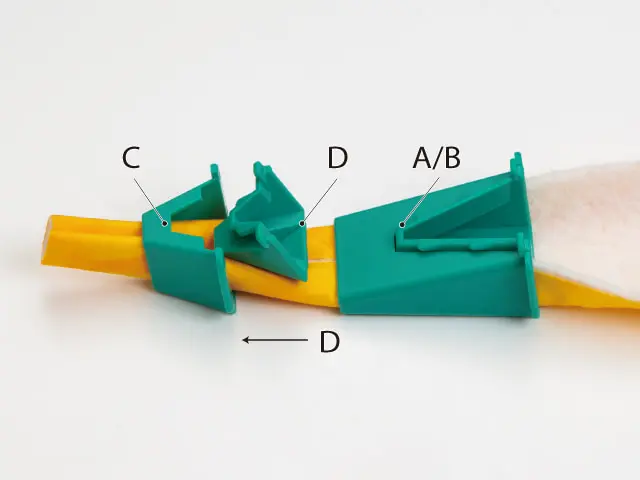 Colorful plastic demonstration device with teal clamps labeled C, D, and A/B along a yellow bar.