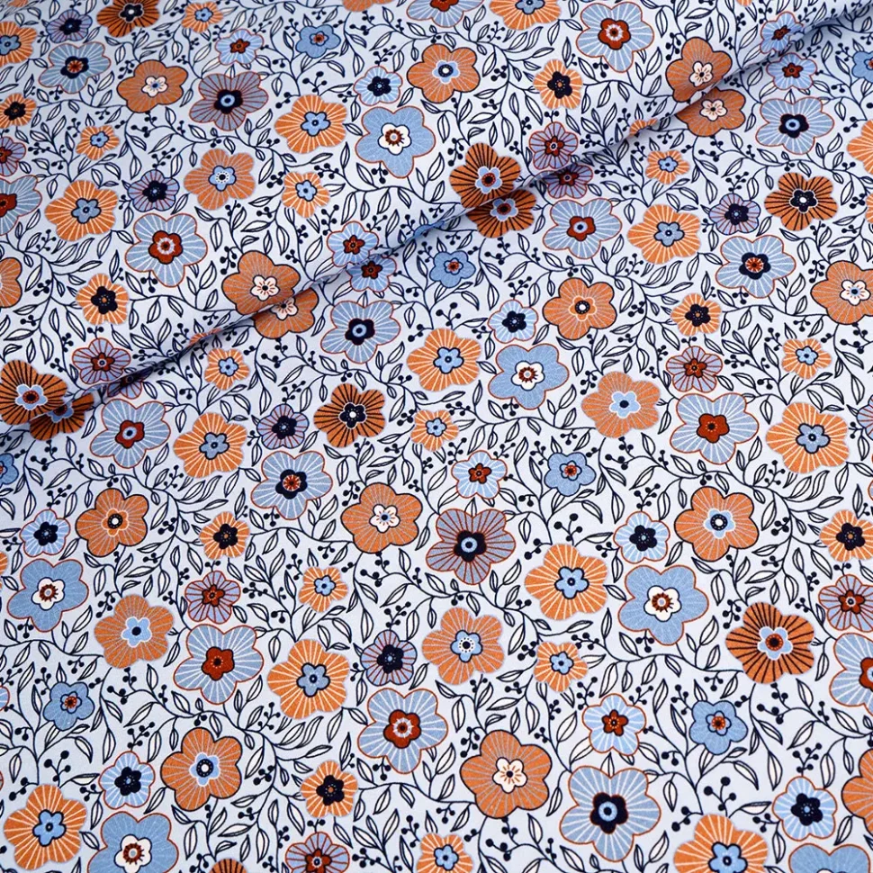 Patterned fabric with orange, blue, and navy flowers and dark vines on a white background (floral print)
