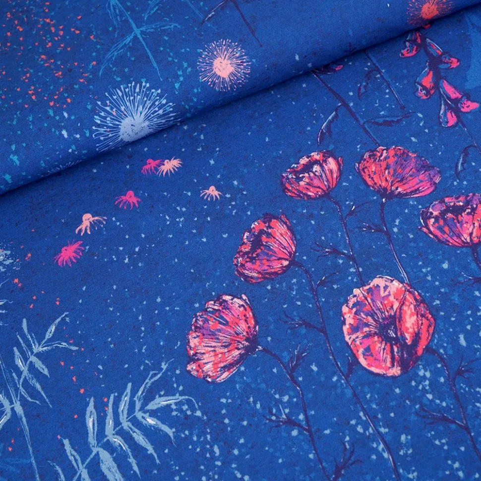 Blue fabric close-up featuring pink blossoms and light blue burst accents on a cobalt background.