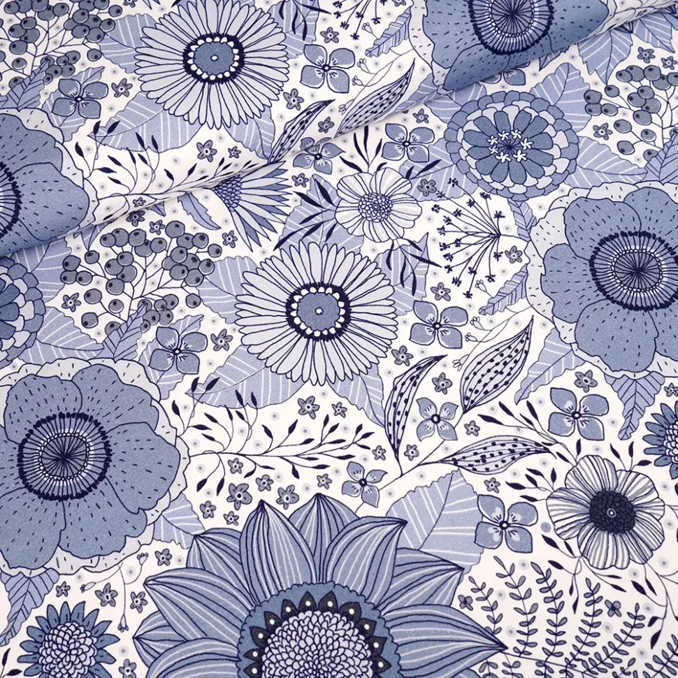 Blue and white floral fabric pattern with large blossoms and detailed leaves, in navy and light blue tones.